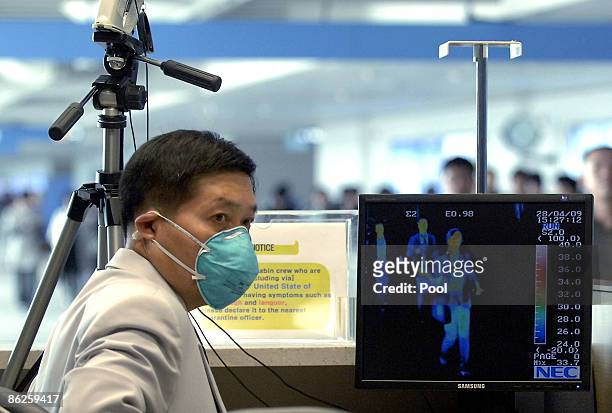 South Korean quarantine officer monitors a thermal scanner as passengers from an international flight arrive at Incheon International Airport on...