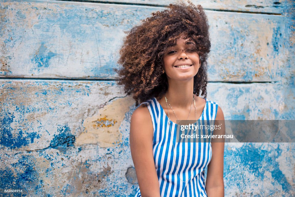 Beautiful young woman against weathered blue wall