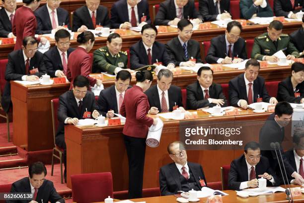 Attendants refill delegate's cups as Jiang Zemin, China's former president, bottom center, sits with eyes closed next to Li Keqiang, China's premier,...