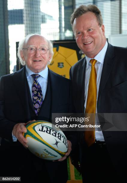 Irish President Michael D. Higgins holds a rugby ball with Australian Rugby Union CEO Bill Pulver at the ARU headquarters in Sydney on October 18,...