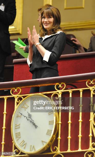 French First Lady Carla Bruni-Sarkozy applauds as French President Nicolas Sarkozy enters the hemicycle in the Chamber of Deputies at the Spanish...