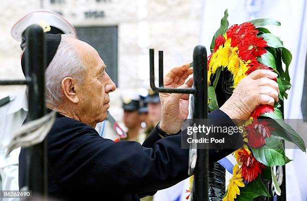 Israeli President Shimon Peres hangs a wreath during Memorial Day at Mount Herzl on April 28, 2009 in Jerusalem, Israel. Israel's Memorial Day pays...