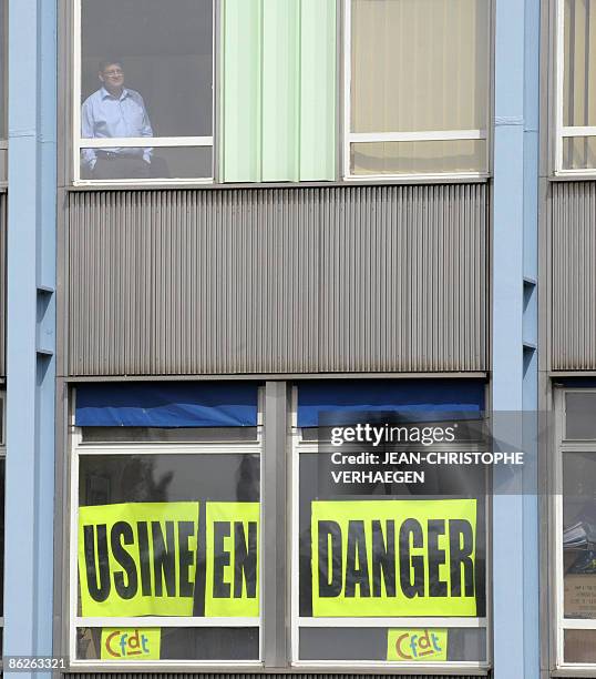 Person looks at workers from steel giant Arcelor-Mittal plant in Florange, eastern France, demonstrating in front of the plant on April 28, 2009....