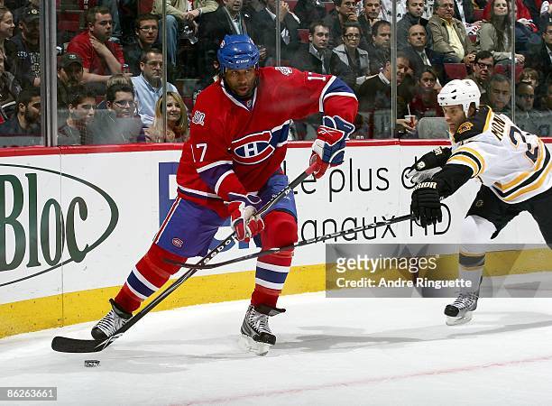 Georges Laraque of the Montreal Canadiens skates against Steve Montador of the Boston Bruins during Game Four of the Eastern Conference Quarterfinal...