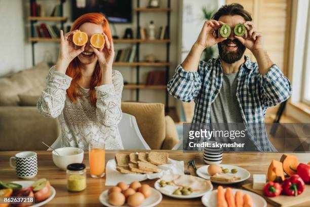 俏皮夫婦在早餐時間在家裡有樂趣。 - kiwi fruit 個照片及圖片檔