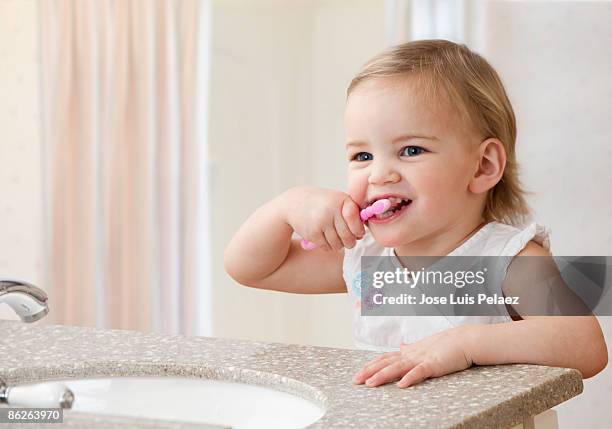 toddler girl brushing teeth - one baby girl only bildbanksfoton och bilder