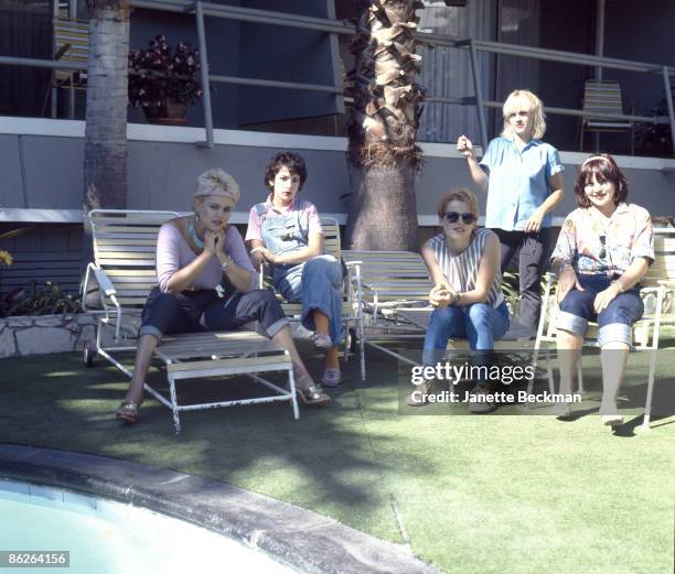 Portrait of music group the Go-Go's as they pose by the swimming pool in the courtyard of the Tropicana Hotel, Los Angeles, California, 1979....