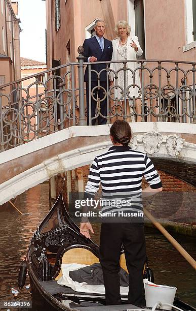 Prince Charles, Prince of Wales and Camilla, Duchess of Cornwall cross a bridge overlooking a canal with a gondola during day 2 of their tour of...