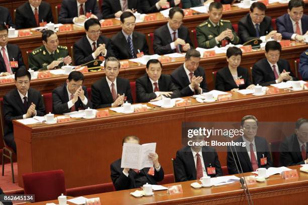 Jiang Zemin, China's former president, front row from left, reads a copy of a report as Li Keqiang, China's premier, Yu Zhengsheng, chairman of the...