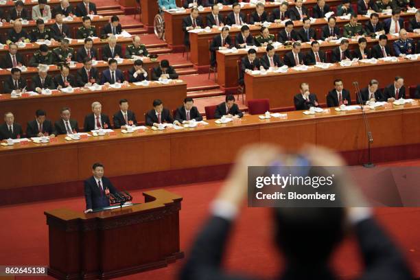 Person takes a photograph with a smartphone as Xi Jinping, China's president, speaks during the opening of the 19th National Congress of the...