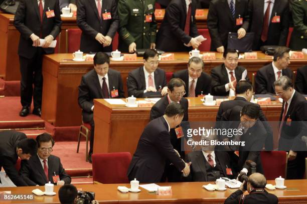 Xi Jinping, China's president, center, shakes hands with Jiang Zemin, China's former president, after delivering his speech at the opening of the...