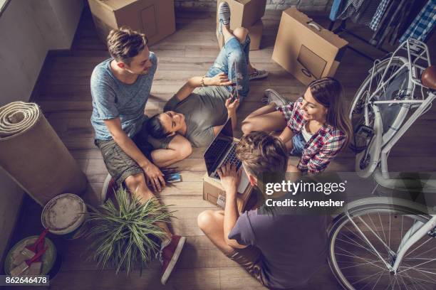 acima vista de colegas de quarto felizes usando a tecnologia sem fio no novo apartamento. - parceiro de apartamento - fotografias e filmes do acervo