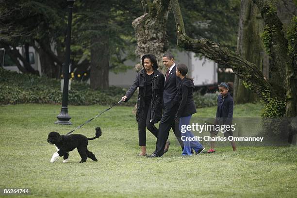 President Barack Obama, first lady Michelle Obama and their daughters, Sasha and Malia, introduce their new dog, a Portuguese water dog named Bo, to...