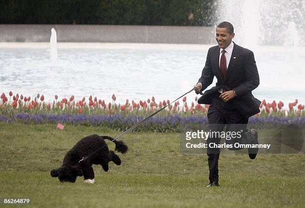 President Barack Obama, first lady Michelle Obama and their daughters, Sasha and Malia, introduce their new dog, a Portuguese water dog named Bo, to...