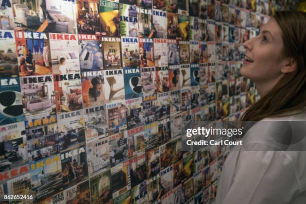 Member of staff poses next to a wall showing IKEA brochure covers over the last 30 years, in the IKEA house on October 17, 2017 in London, England....