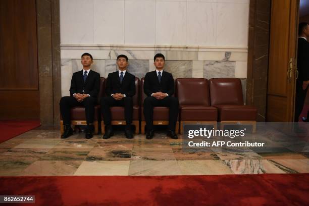 Security guards wait in the Great Hall of the People as Chinese President Xi Jinping speaks during the opening ceremony of the 19th Communist Party...