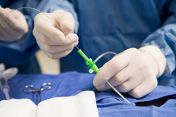 Surgeon inserting tube into patient during surgery via a catheter in an operating room