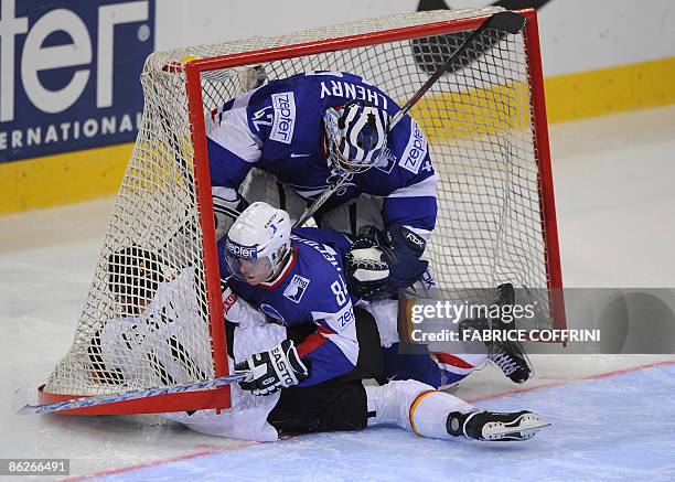 Germany's Sven Felski falls in the cage with France's Kevin Hecquefeuille and his teammate goalie Fabrice Lhenry during their preliminary round game...