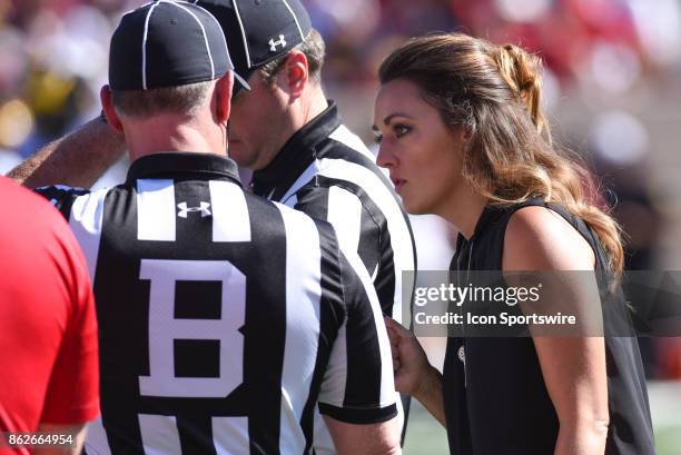 Reporter Allison Williams speaking with game officials during a stoppage in play during a college football game between the Michigan Wolverines and...