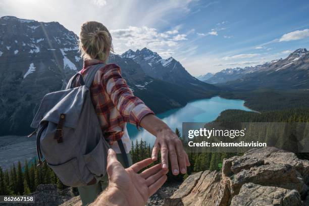 follow me to, young woman leading man to mountain top - follow me stock pictures, royalty-free photos & images