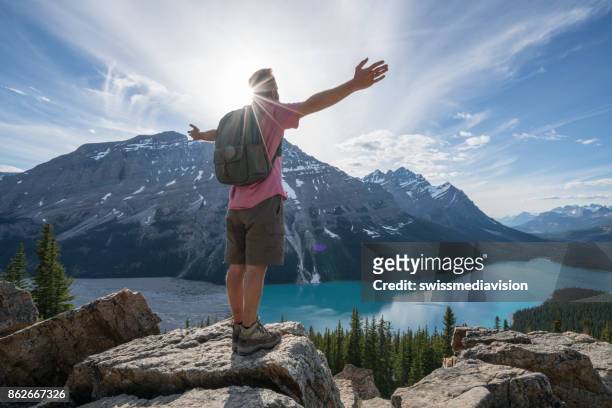 hiker male on mountain top celebrating achievement - peyto lake stock pictures, royalty-free photos & images