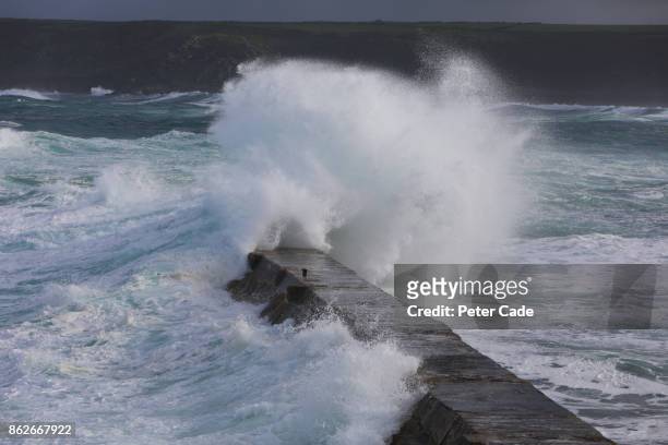 rough sea hitting jetty - sennen imagens e fotografias de stock