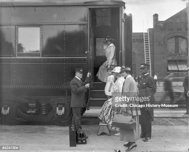 Pullman porter assists a woman and child in boarding the train, Chicago, IL, ca.1915. Chicago served as America's rail capital during the Great Age...