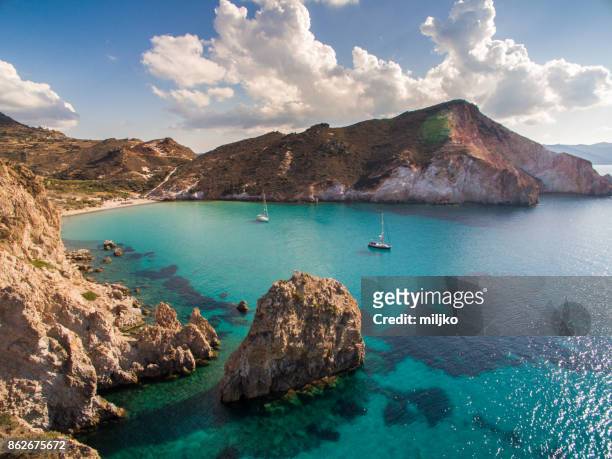 sailboats anchored in bay at milos island - greece stock pictures, royalty-free photos & images