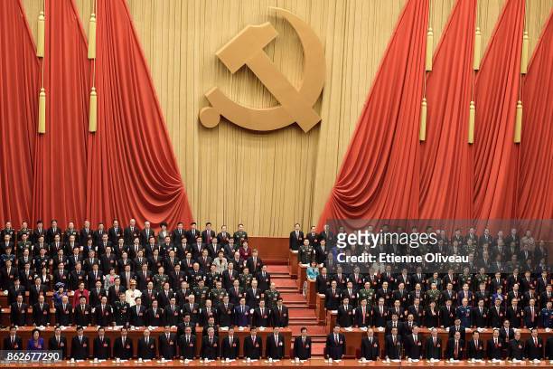 Chinese President Xi Jinping stands up to listen to the National Anthem among other members of the Communist Party Of China during the opening...
