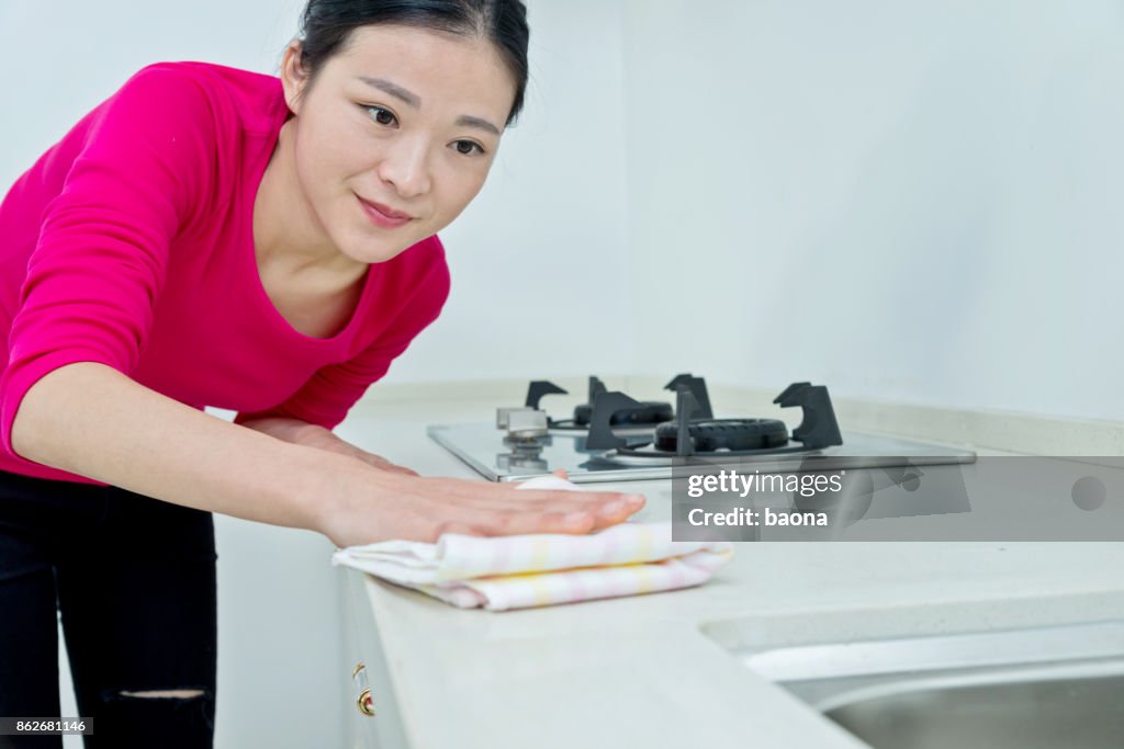 Beautiful woman cleaning the kitchen counter