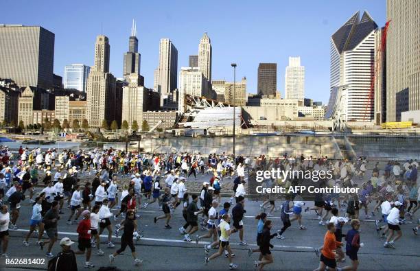 Runners race through Grant Park in downtown Chicago at the start of the 25th annual Chicago Marathon 13 October, 2002. 37,500 runners registered for...