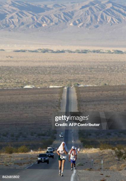 Peter Meyer from Germany covers his head with a white towel to stay cool as he races in the Kiehl's Badwater Ultramarathon 23 July 2007 in Death...