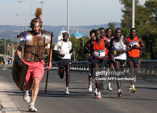 Tom Podesta from the US dressed as an ancient Greek warrior runs next to leading group with the Kenyan winner of the Athens Classic Marathon Henry...