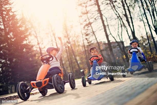 kids in small cars racing n the park - go cart stock pictures, royalty-free photos & images