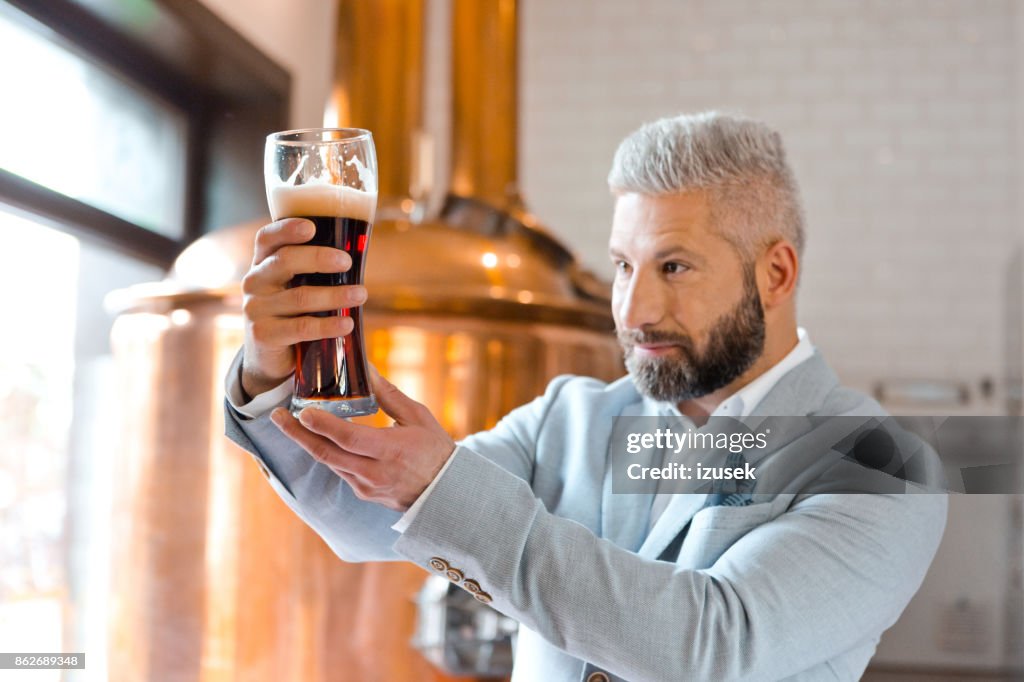 De microbrouwerij eigenaar chceking kwaliteit van bier in zijn kroeg