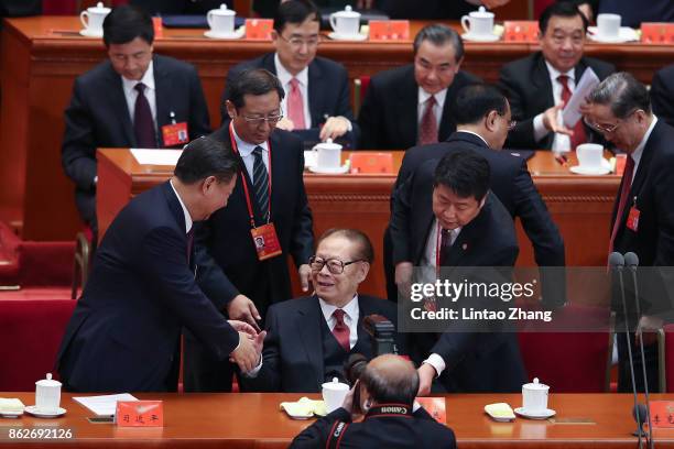 Chinese President Xi Jinping shake hands China's former president Jiang Zemin at the opening session of the Chinese Communist Party's Congress at the...