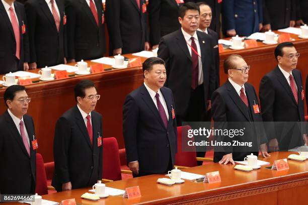 Chinese President Xi Jinping and other Chinese politicians and delegates listen to the national anthem duirng the opening session of the Chinese...