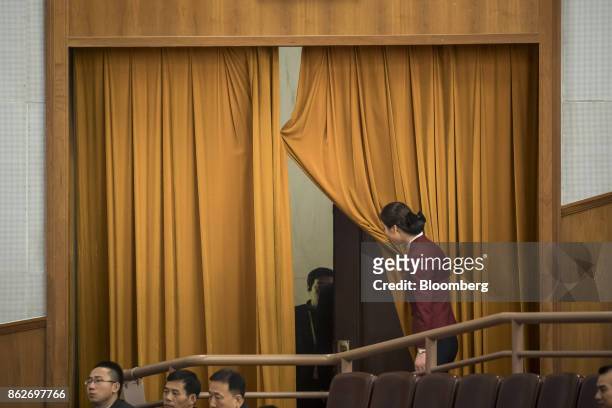 An attendant opens a curtain during the opening of the 19th National Congress of the Communist Party of China at the Great Hall of the People in...