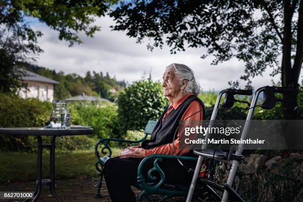 großmutter mit rollator sitzt auf parkbank - dementia stock-fotos und bilder
