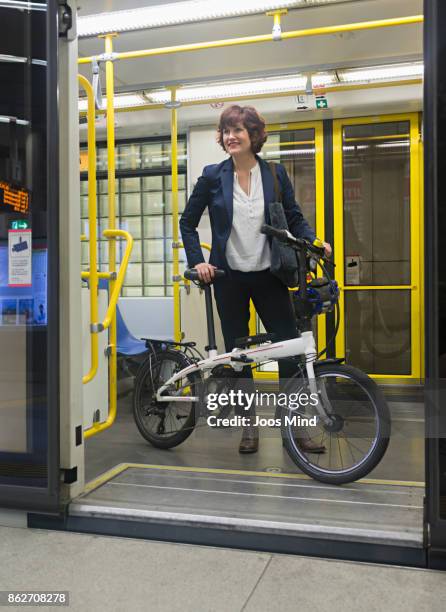 businesswoman with folding bike in subway train - no pants subway stock pictures, royalty-free photos & images