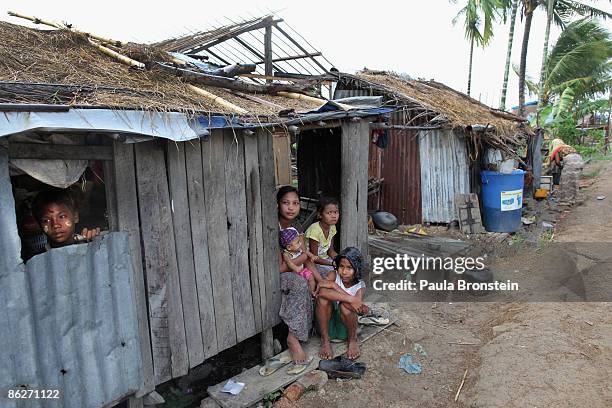 Burmese family sits inside their shack on April 27, 2009 in the Irrawady delta village of Ma Lot Myit Than, Myanmar .A year after the devastating...