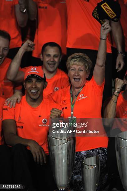 McLaren Mercedes' British driver Lewis Hamilton poses with his mother Carmen Larbalestier and the McLaren Mercedes team at the Yas Marina circuit on...