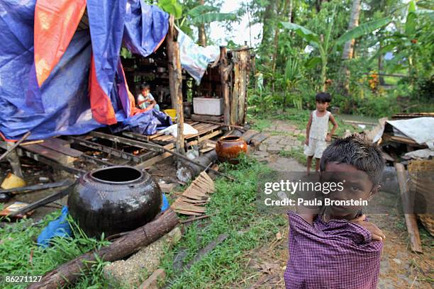Burmese child stands outside her shack covered with plastic tarps to protect from the rain on April 27, 2009 in the Irrawady delta village of Ma Lot...
