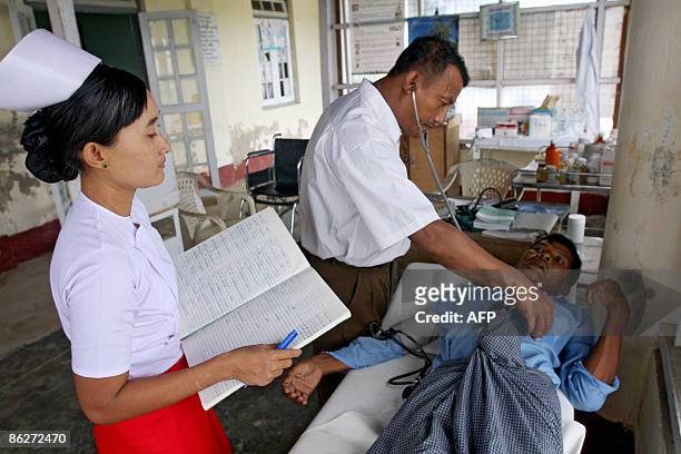 By Claire TRUSCOTT In this picture taken on April 22, 2009 at the Cyclone Nargis-affected Pyinsalu town, in Myanmar's Irrawaddy delta, a doctor and a...