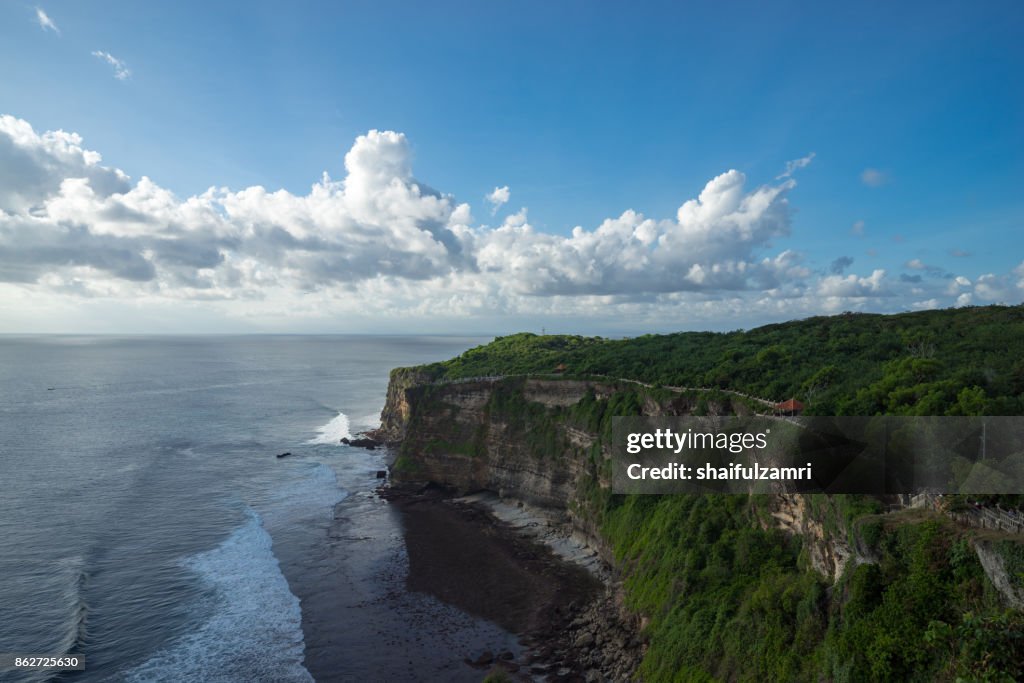 A scenic Uluwatu cliff with pavilion and blue sea in Bali, Indonesia.