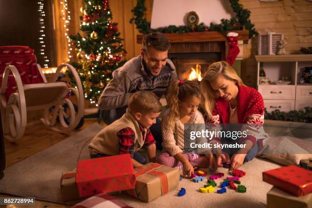 happy family playing with puzzles during new year's holidays at home. - happy holidays family stock pictures, royalty-free photos & images