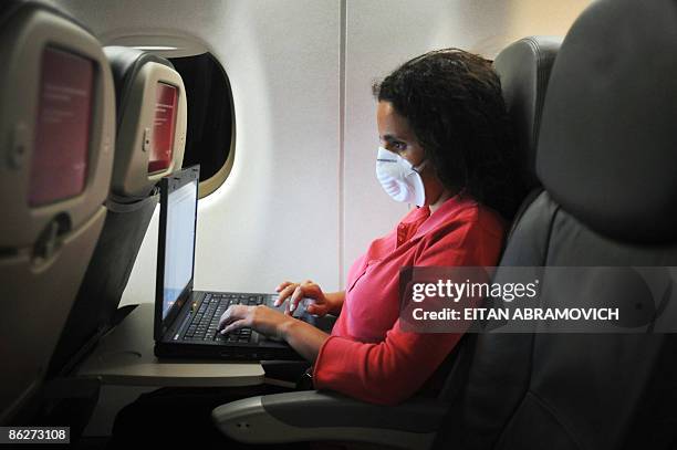 Passenger wears a protective mask during a flight from Guatemala to Mexico on April 28, 2009. Mexico's government kept the country's public venues...