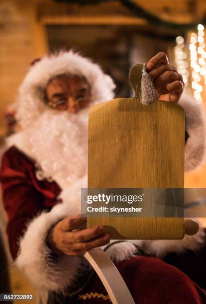 nahaufnahme des weihnachtsmannes lesen wunschliste an heiligabend. - santa close up stock-fotos und bilder