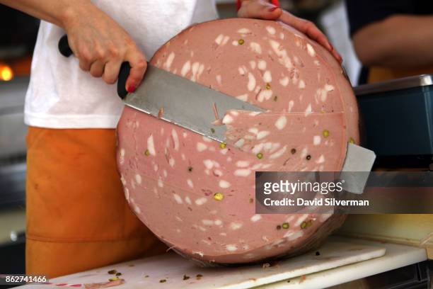 July 25: Mortadella salami is sliced by hand at the weekly farmers' market July 25, 2015 in the village of Castellina in the Tuscany region of Italy....