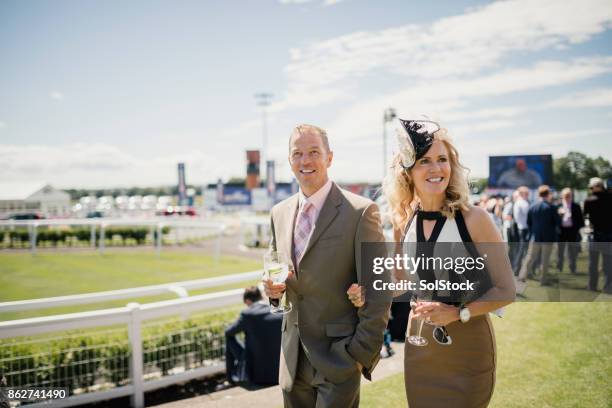 couple enjoying a drink on race day - racecourse ground stock pictures, royalty-free photos & images